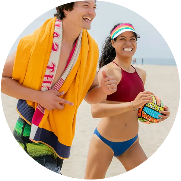 man and woman running on the beach in sportswear swim suits